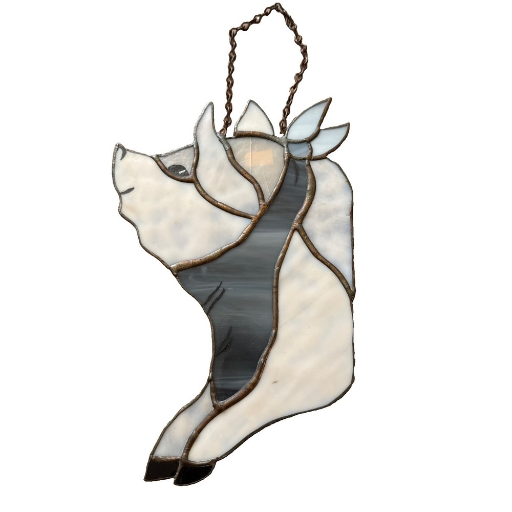 handmade stained glass sun catcher of a pig with opalescent glass pieces.